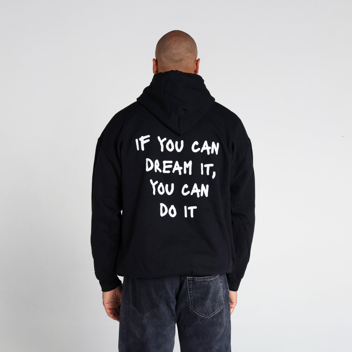 Logo distintivo sulla parte anteriore della felpa nera" "Frase iconica di Marcell Jacobs 'If you can dream it you can do it' in bianco sulla parte posteriore della felpa nera"