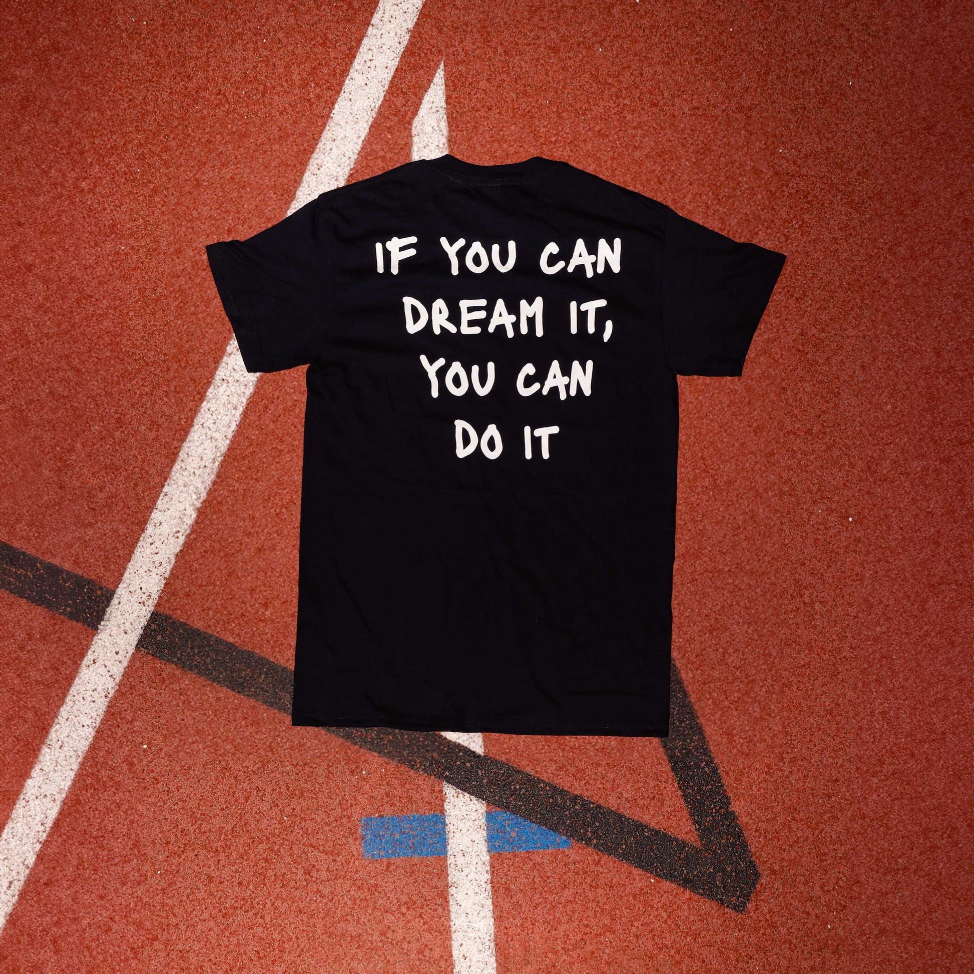 Logo distintivo sulla parte anteriore della maglia nera" "Frase iconica di Marcell Jacobs 'If you can dream it you can do it' in bianco sulla parte posteriore della maglia nera"