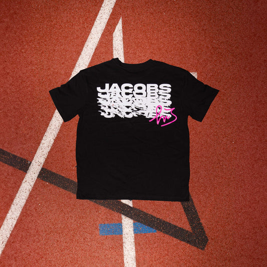 Logo distintivo sulla parte anteriore della maglia nera" "Schema ripetuto della scritta 'Jacobs' sulla parte posteriore della maglia nera in colore magenta con firma di Marcell Jacobs"